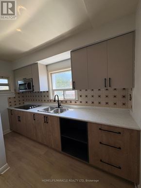Toronto (Clairlea-Birchmount) apartment for rent - A kitchen with wooden cabinets and a white countertop.