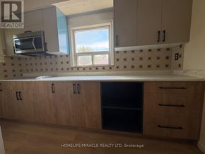 Toronto (Clairlea-Birchmount) apartment for rent - A kitchen with wooden cabinets and a microwave above the counter.