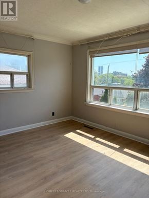 Toronto (Clairlea-Birchmount) apartment for rent - A room with wooden flooring and two windows.