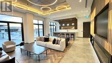 Richmond Hill (South Richvale) condo for rent - A modern living room with a large white sofa and a television on the wall.