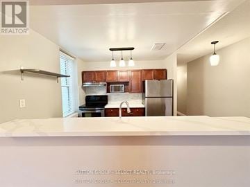 London East (East F) condo for rent - A kitchen with a refrigerator, microwave, and oven.