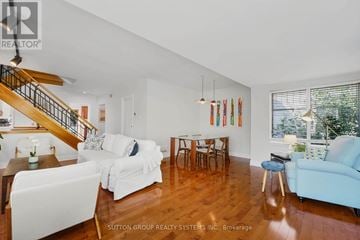 Toronto (Cliffcrest) apartment for rent - A living room with white furniture and a wooden staircase.