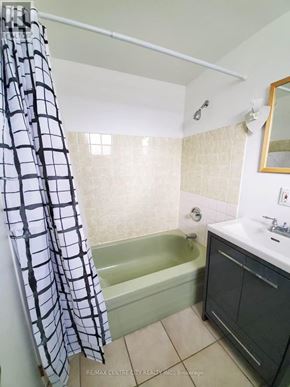 London North (North K) apartment for rent - A bathroom with a shower curtain, sink, and bathtub.