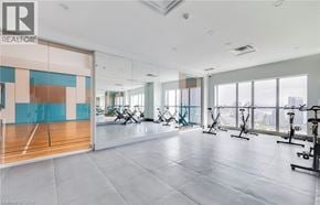 Toronto condo for rent - A spacious gym with a row of exercise bikes and a yoga mat.