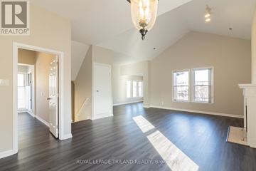 London East (East F) multi-family for rent - A large, empty room with wooden floors and a chandelier hanging from the ceiling.