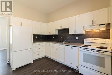 London East (East F) multi-family for rent - A white refrigerator is in a kitchen with white cabinets.
