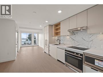 North Vancouver apartment for rent - A modern kitchen with white appliances and a marble backsplash.