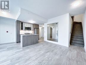 Toronto (Mimico) house for rent - A spacious living room with a staircase leading to the upper floor.