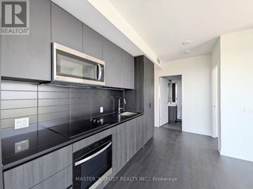 Toronto (Newtonbrook West) condo for rent - A modern kitchen with dark grey cabinets and a black countertop.