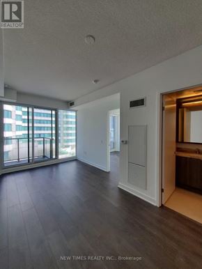Toronto (Waterfront Communities) condo for rent - A spacious room with a view of a balcony and a door leading to another room.
