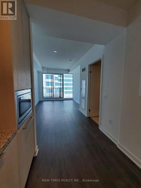 Toronto (Waterfront Communities) condo for rent - A spacious hallway with a window and a door leading to another room.
