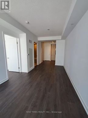 Toronto (Waterfront Communities) condo for rent - A long hallway with wood floors and white walls.
