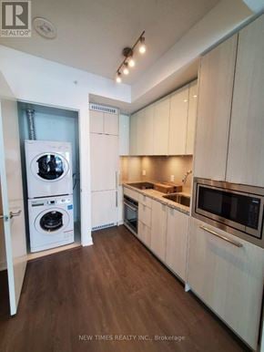 Toronto (Waterfront Communities) condo for rent - A modern kitchen with white cabinets and a microwave.