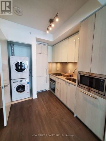 Toronto (Waterfront Communities) condo for rent - A modern kitchen with white cabinets and a microwave.