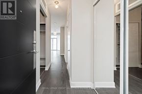 Toronto (Waterfront Communities) condo for rent - A hallway with a black door on the left and white walls on the right.