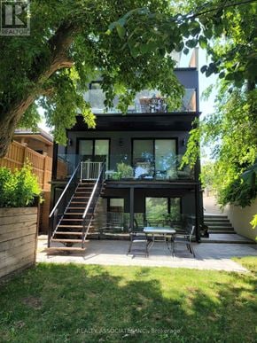Toronto (Caledonia-Fairbank) apartment for rent - A modern house with a glass table and chairs in the backyard.