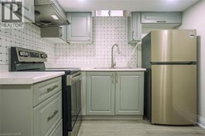 Milton apartment for rent - A kitchen with a stainless steel refrigerator and a black stove top oven.
