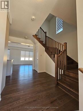 Kitchener apartment for rent - A wooden staircase leads up to a brightly lit second floor.