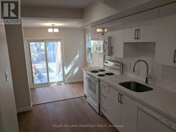Toronto (Woodbine Corridor) apartment for rent - A kitchen with white cabinets and a stove top oven.