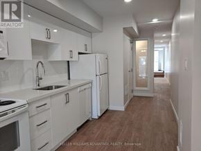 Toronto (Woodbine Corridor) apartment for rent - A modern kitchen with white cabinets and a wooden floor.