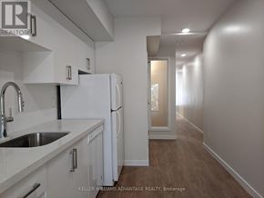 Toronto (Woodbine Corridor) apartment for rent - A white kitchen with a sink and a refrigerator.