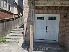 Whitby (Blue Grass Meadows) apartment for rent - A white double door with a black handle is on the right side of a brick wall.
