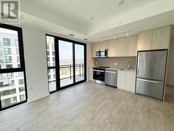 Milton (Cb Cobban) condo for rent - A spacious kitchen with a refrigerator, microwave, and stove top oven.