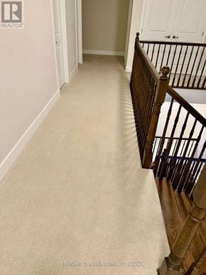 Ottawa apartment for rent - A hallway with a carpeted floor and a wooden staircase.
