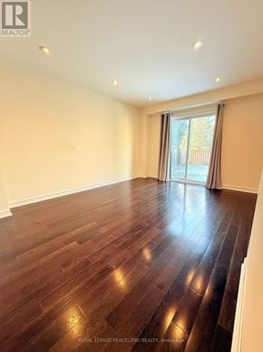 Markham (Markville) apartment for rent - A spacious room with wooden flooring and a large window.