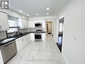 Vaughan (Brownridge) apartment for rent - A modern kitchen with white cabinets and a black countertop.