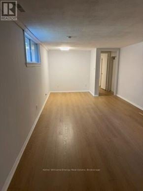 Pickering (West Shore) apartment for rent - A long, empty room with wooden floors and white walls.