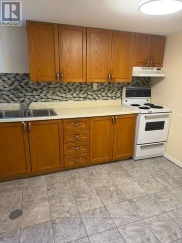 Pickering (West Shore) apartment for rent - A kitchen with wooden cabinets and a white stove top oven.