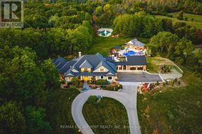 Burlington (Grindstone) apartment for rent - A large house with a pool is surrounded by trees and has a driveway leading to the front door.