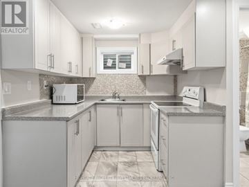 Brampton (Madoc) apartment for rent - A kitchen with white cabinets and a granite countertop.