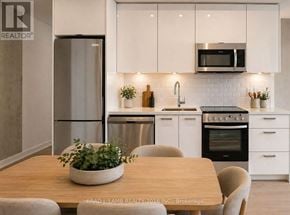 Toronto (Moss Park) condo for rent - A modern kitchen with a wooden table and chairs.