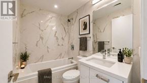 Toronto (Moss Park) condo for rent - A bathroom with marble walls and a white countertop.