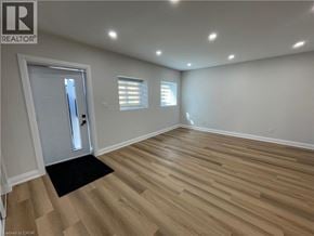 Kitchener apartment for rent - A room with wooden flooring and a door leading to another room.