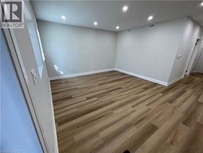 Kitchener apartment for rent - A room with wooden flooring and white walls.