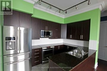 Markham (Unionville) condo for rent - A kitchen with a stainless steel refrigerator and a black countertop.