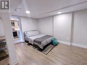 Toronto (Palmerston-Little Italy) apartment for rent - A bedroom with a bed, a rug, and a backpack.