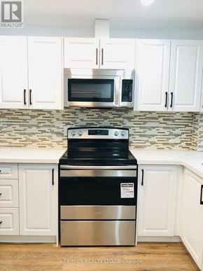 Toronto (South Riverdale) apartment for rent - A kitchen with a stove top oven and microwave above it.