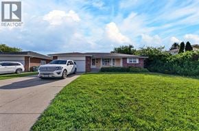 Windsor apartment for rent - A white car is parked in front of a house with a lawn.