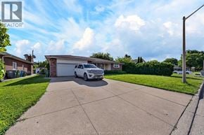 Windsor apartment for rent - A white car is parked in a driveway in front of a house.