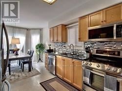 Newmarket (Summerhill Estates) apartment for rent - A kitchen with wooden cabinets and a black stove top oven.