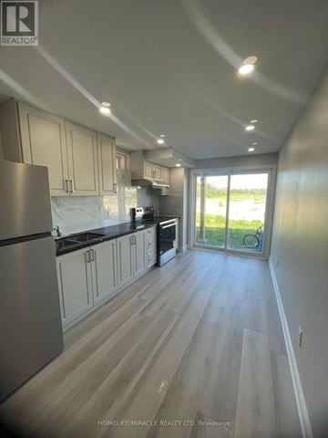 Barrie apartment for rent - A kitchen with wooden floors and a large refrigerator.