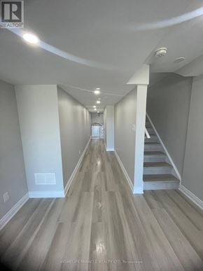 Barrie apartment for rent - A long hallway with wood flooring and white walls.