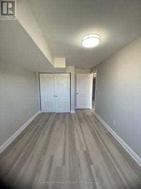 Barrie apartment for rent - A hallway with wood flooring and white walls.