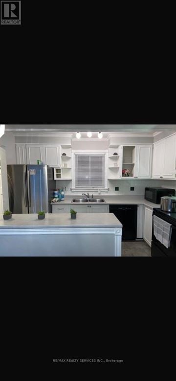 Brampton (Central Park) apartment for rent - A modern kitchen with white cabinets and a large island.