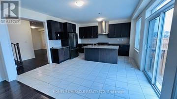 Brampton (Credit Valley) apartment for rent - A spacious kitchen with black cabinets and a white tiled floor.