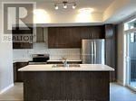 Kitchener townhouse for rent - A kitchen with a refrigerator and a sink.